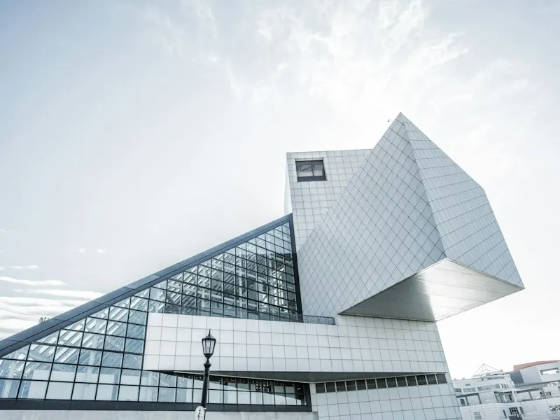 Bâtiment contemporain à façade vitrée et volumes anguleux, vu d’en bas